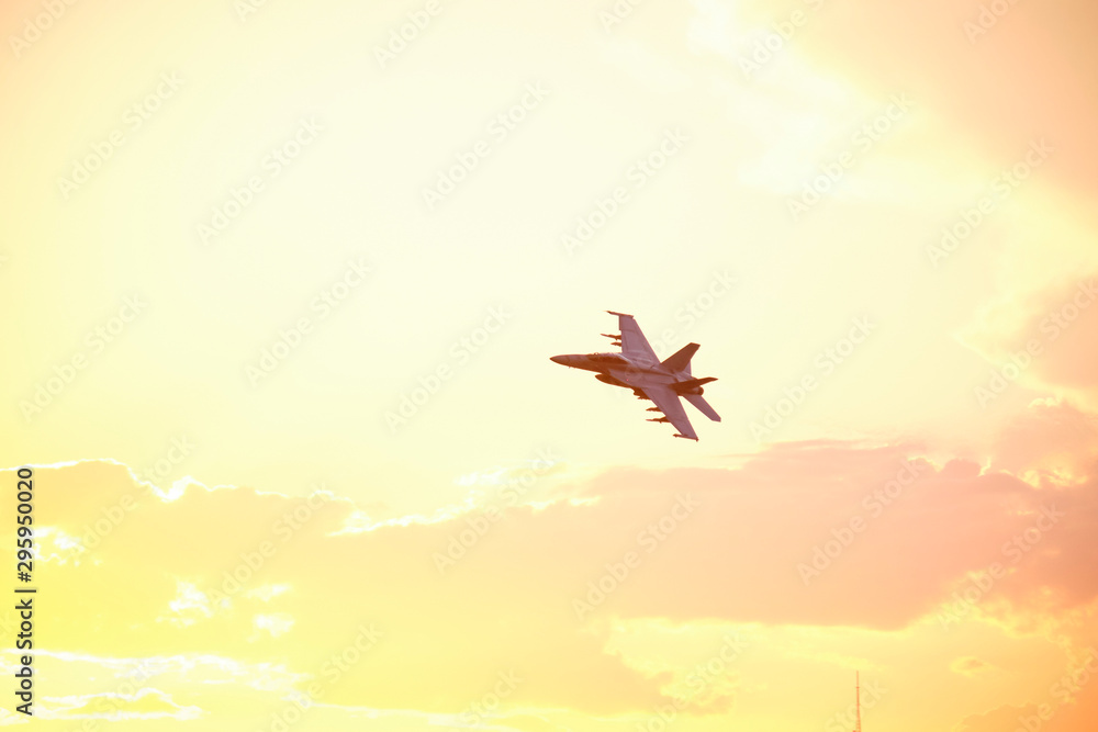 Naklejka premium Australian Air Force fighter jet flying through Brisbane at sunset