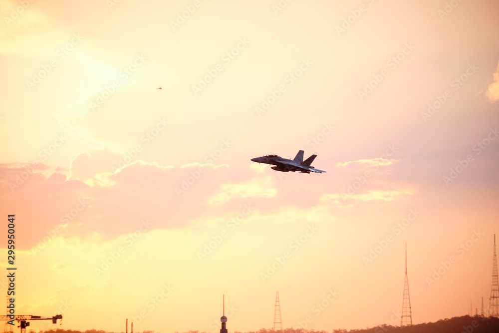 Australian Air Force fighter jet flying through Brisbane at sunset Australian Air Force fighter jet flying through Brisbane at sunset