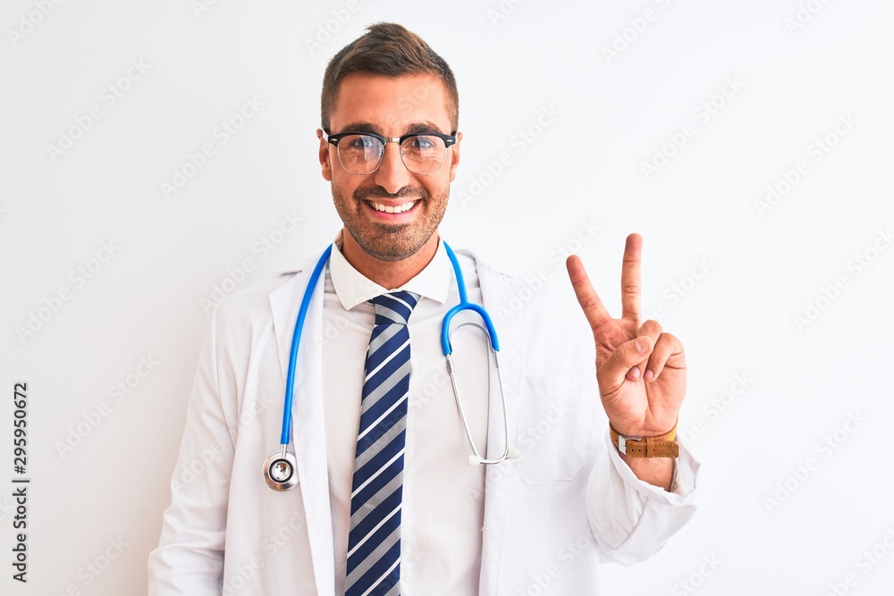 Young handsome doctor man wearing stethoscope over isolated background showing and pointing up with fingers number two while smiling confident and happy. Young handsome doctor man wearing stethoscope over isolated background showing and pointing up with fingers number two while smiling confident and happy.