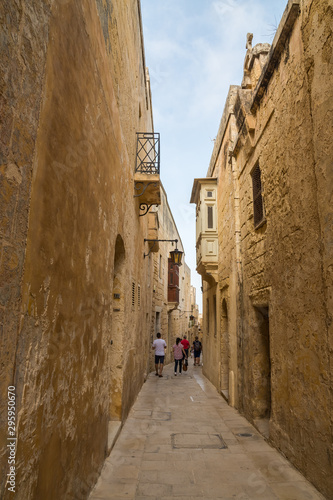 Tourists Exploring a Narrow Quiet Street of the Medieval City of Mdina  Malta 
