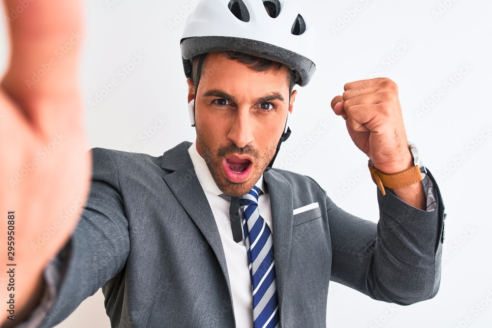 Young handsome business man wearing bike helmet taking a selfie over isolated background annoyed and frustrated shouting with anger, crazy and yelling with raised hand, anger concept Young handsome business man wearing bike helmet taking a selfie over isolated background annoyed and frustrated shouting with anger, crazy and yelling with raised hand, anger concept