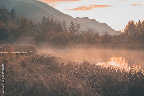 Early morning in the nature reservate of Zelenci, Slovenia, the spring of Sava Dolinka river. Beautiful dreamy morning setting, fairy tale vivid colors and still lake visible. photo