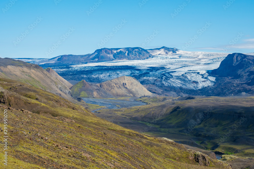 Icelandic landscape with eyjafjallajokull glacier tongue, Markarfljot river and green hills. Fjallabak Nature Reserve, Iceland. Summer blue sky