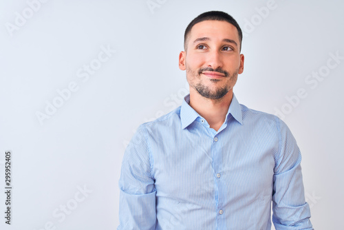 Young handsome business man standing over isolated background smiling looking to the side and staring away thinking.