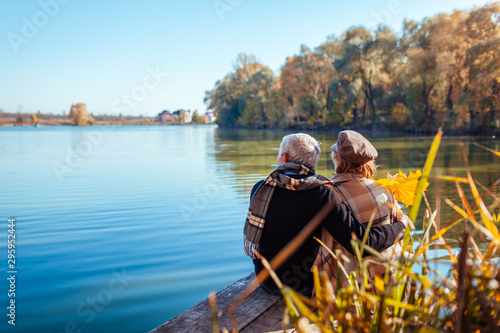 Foto Senior couple relaxing by autumn lake