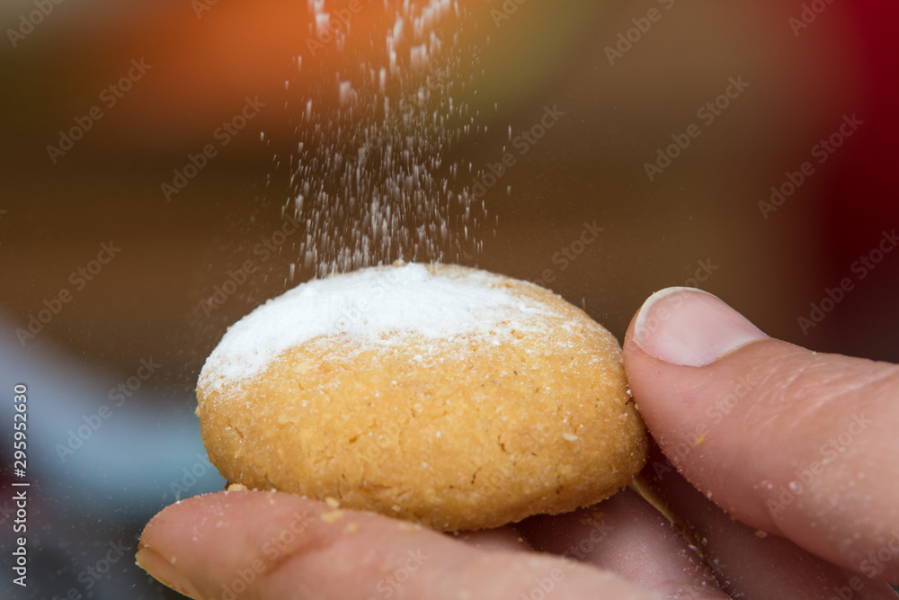 Fototapeta premium Pouring powdered sugar on a Christmas cookie