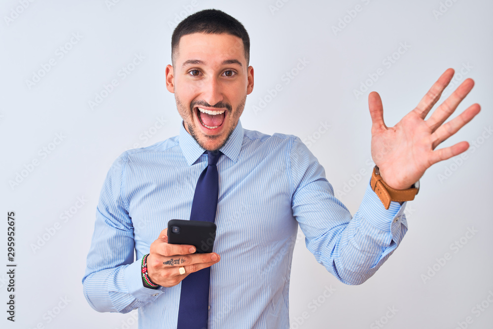 Young handsome business man using smartphone over isolated background very happy and excited, winner expression celebrating victory screaming with big smile and raised hands Young handsome business man using smartphone over isolated background very happy and excited, winner expression celebrating victory screaming with big smile and raised hands