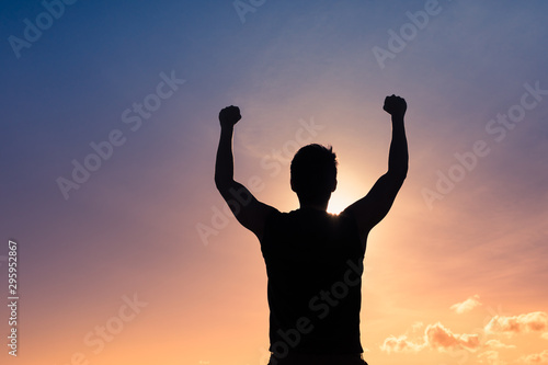 Strong young man with fist in the air. Triumph, victory and feeling determined.