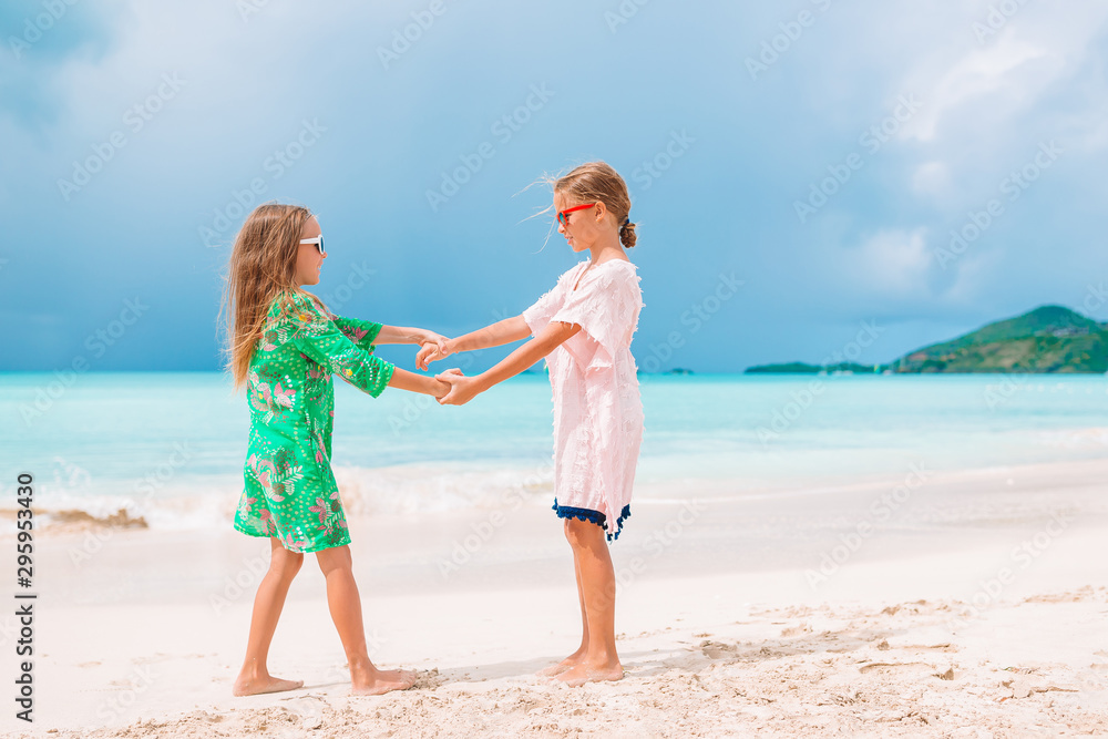 Little girls having fun enjoying vacation on tropical beach