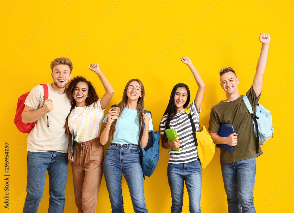 Group of happy students on color background - obrazy, fototapety, plakaty 
