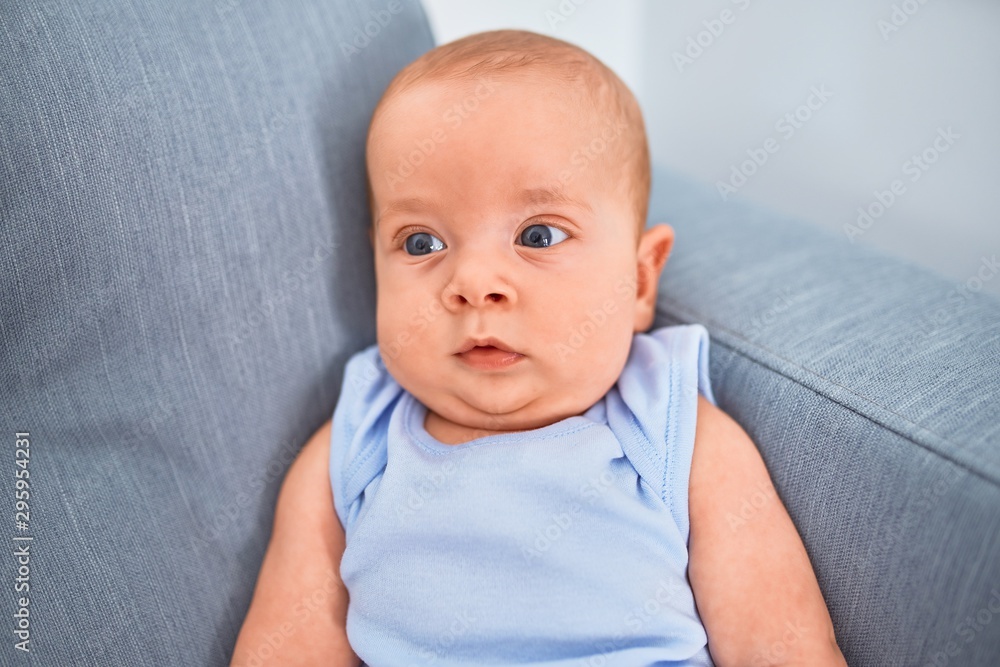 Adorable baby lying down on the sofa at home. Newborn relaxing and resting comfortable Adorable baby lying down on the sofa at home. Newborn relaxing and resting comfortable