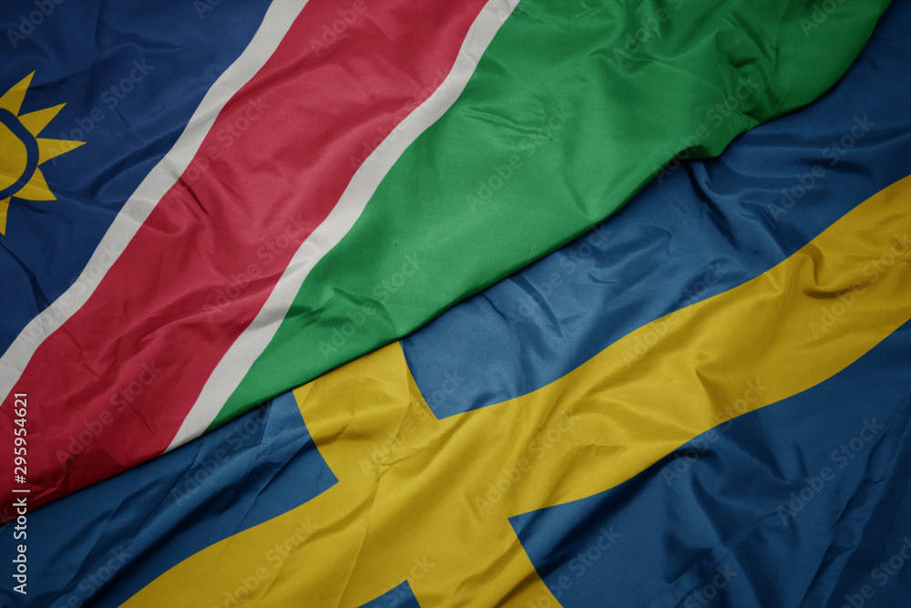 waving colorful flag of sweden and national flag of namibia. waving colorful flag of sweden and national flag of namibia.