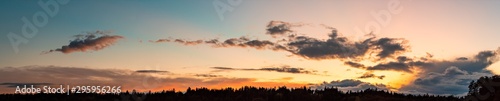 Panorama during sunset over forest with pastel colors sky and colorful clouds