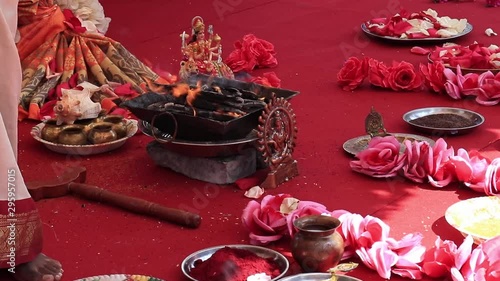 Indian wedding ceremony, decorations for traditional ethnic rituals for marriage, fire burning, flowers and statuettes of the deity on red carpet