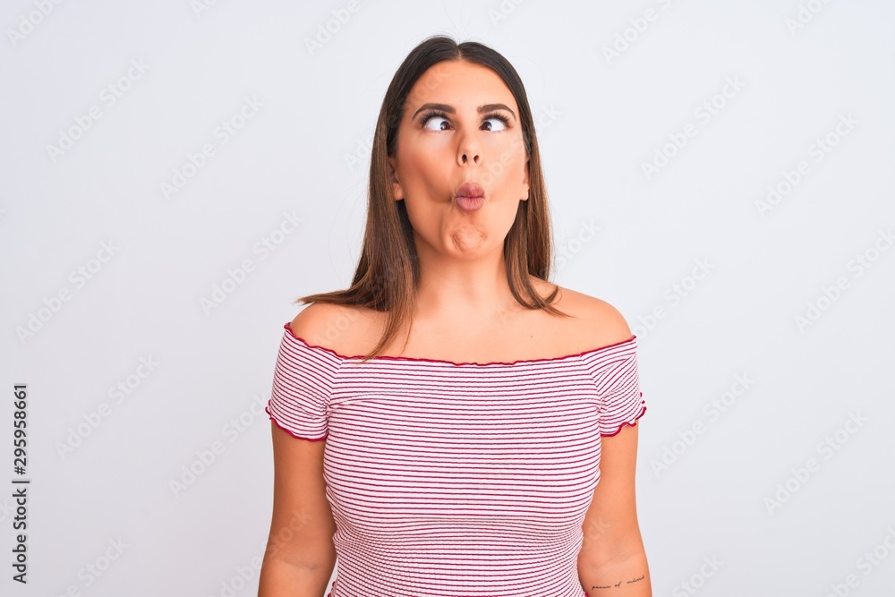 Portrait of beautiful young woman standing over isolated white background making fish face with lips, crazy and comical gesture. Funny expression. Portrait of beautiful young woman standing over isolated white background making fish face with lips, crazy and comical gesture. Funny expression.