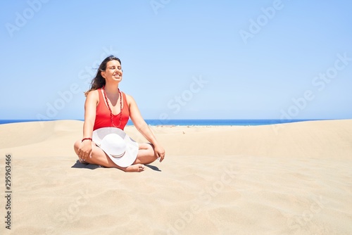 Young beautiful woman sunbathing and relaxing sitting on the sand doing yoga poses at maspalomas dunes bech © Krakenimages.com
