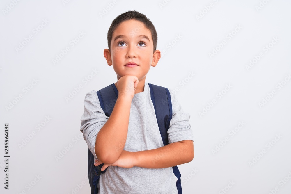Beautiful student kid boy wearing backpack standing over isolated white background with hand on chin thinking about question, pensive expression. Smiling with thoughtful face. Doubt concept. Beautiful student kid boy wearing backpack standing over isolated white background with hand on chin thinking about question, pensive expression. Smiling with thoughtful face. Doubt concept.