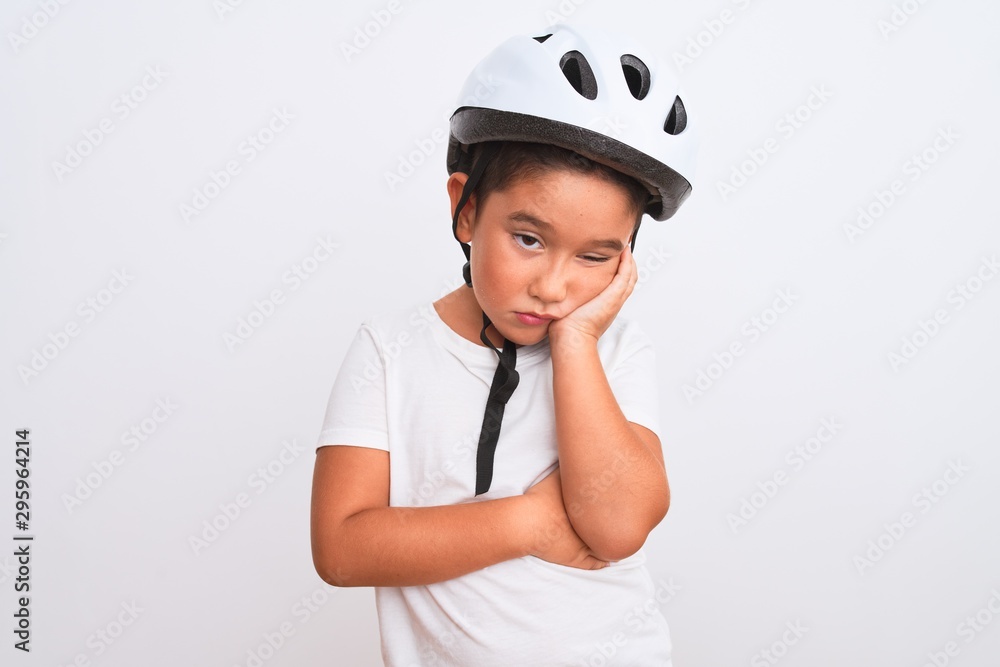 Beautiful kid boy wearing bike security helmet standing over isolated white background thinking looking tired and bored with depression problems with crossed arms. Beautiful kid boy wearing bike security helmet standing over isolated white background thinking looking tired and bored with depression problems with crossed arms.