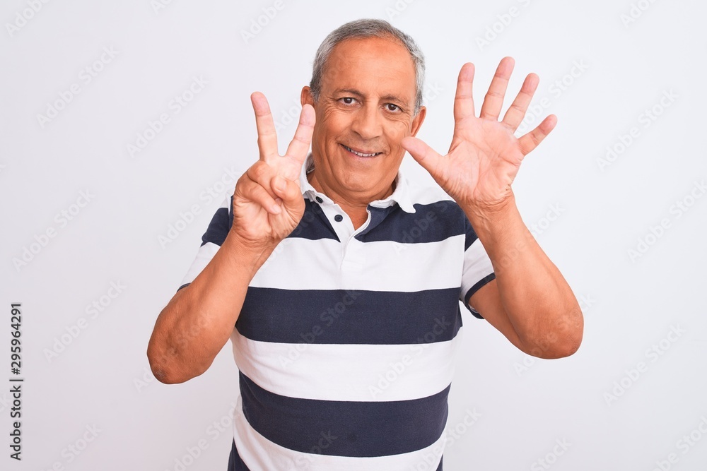 Naklejka premium Senior grey-haired man wearing casual striped polo standing over isolated white background showing and pointing up with fingers number seven while smiling confident and happy.