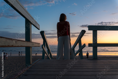 Beautiful Woman Silhouette Watching The Ocean from a Lifeguard Tower in California