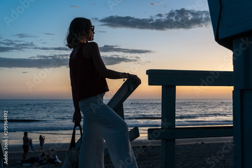 Beautiful Woman Silhouette Watching The Ocean from a Lifeguard Tower in California