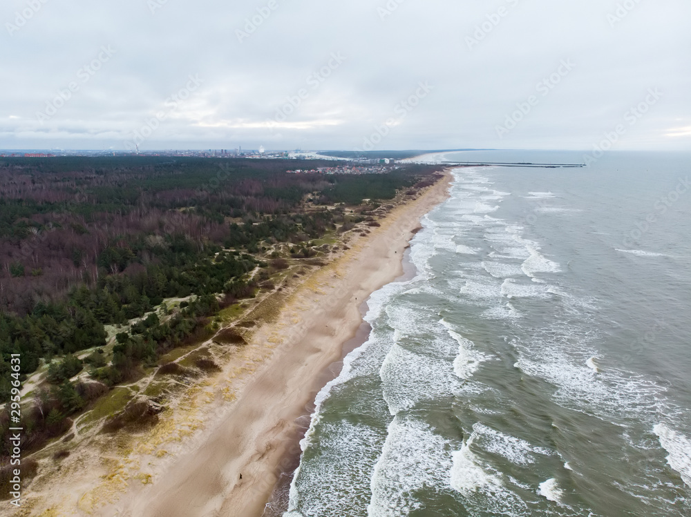 Aerial view of the Baltic Sea shore line near Klaipeda city, Lithuania. Beautiful sea coast on chilly winter day. - obrazy, fototapety, plakaty 