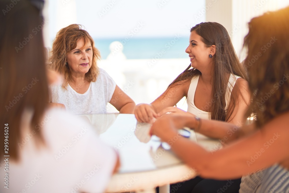 Beautiful group of women sitting at terrace speaking and smiling