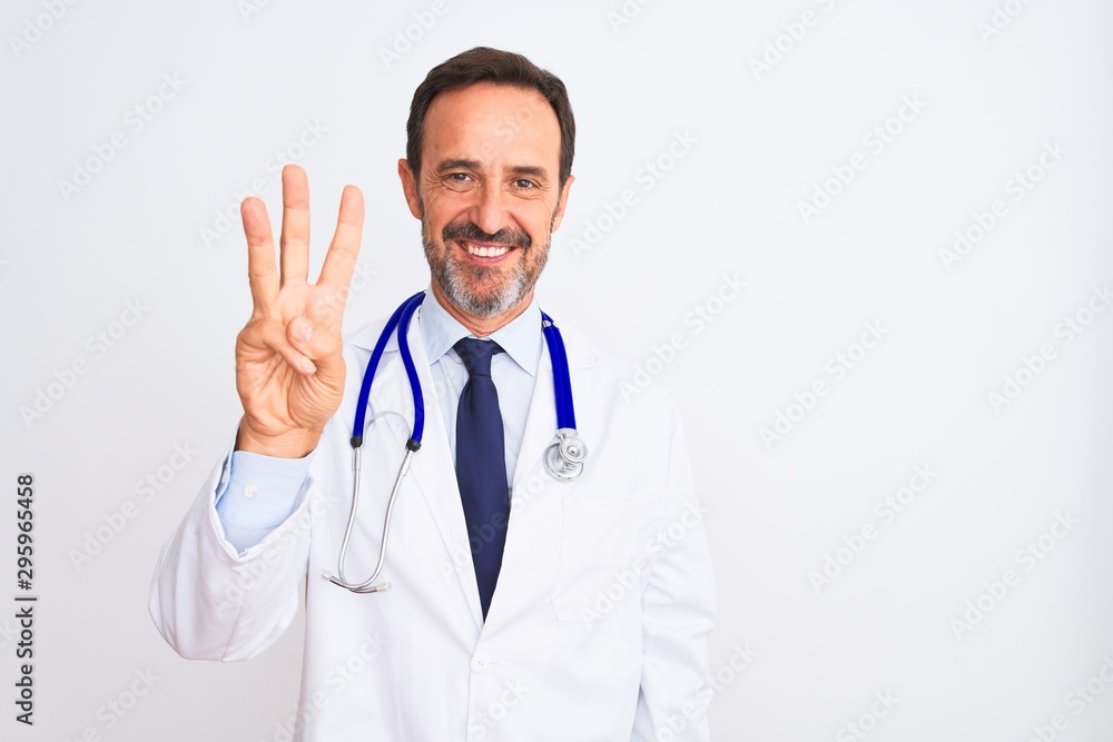 Middle age doctor man wearing coat and stethoscope standing over isolated white background showing and pointing up with fingers number three while smiling confident and happy. Middle age doctor man wearing coat and stethoscope standing over isolated white background showing and pointing up with fingers number three while smiling confident and happy.