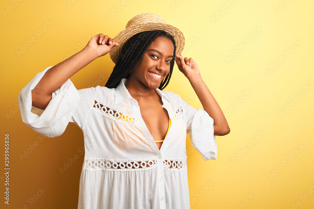 Beautiful african american girl wearing bikini and summer hat smiling happy Beautiful african american girl wearing bikini and summer hat smiling happy