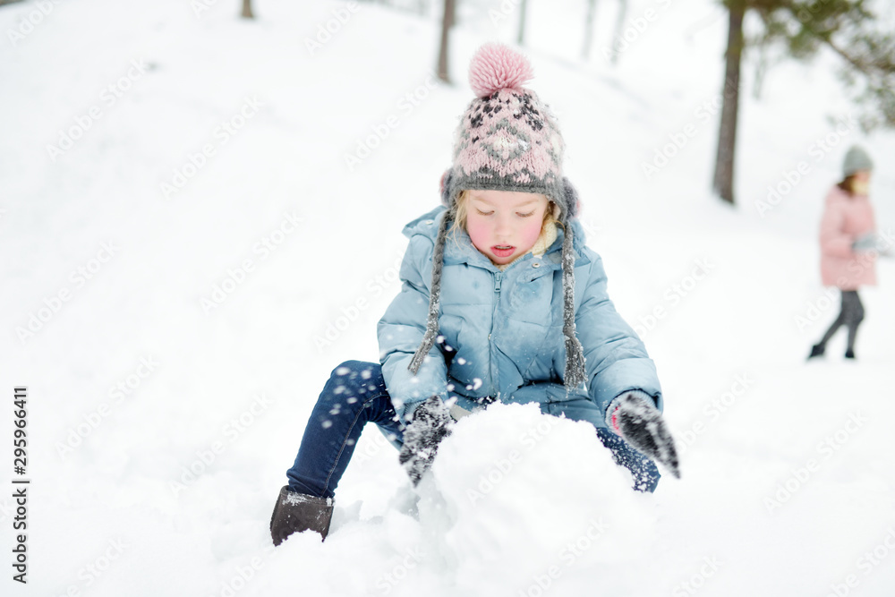 Adorable young girl having fun in beautiful winter park. Cute child playing in a snow. Winter activities for family with kids. Adorable young girl having fun in beautiful winter park. Cute child playing in a snow. Winter activities for family with kids.