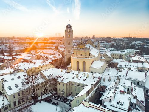 Beautiful Vilnius city panorama in winter with snow covered houses, chruches and streets. Aerial evening view.