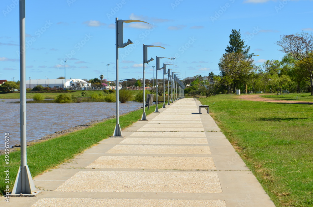 Sidewalk with lampposts on the shore of the lake.