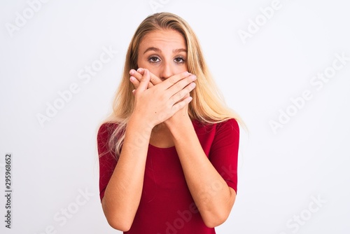 Young beautiful woman wearing red t-shirt standing over isolated white background shocked covering mouth with hands for mistake. Secret concept.