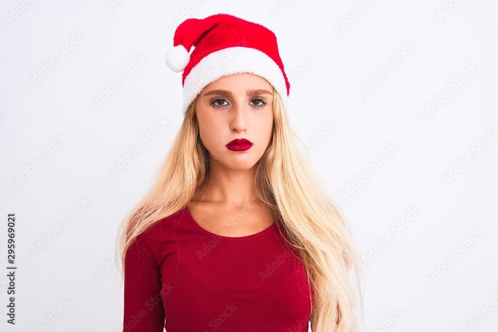 Young beautiful woman wearing Christmas Santa hat over isolated white background depressed and worry for distress, crying angry and afraid. Sad expression. Young beautiful woman wearing Christmas Santa hat over isolated white background depressed and worry for distress, crying angry and afraid. Sad expression.