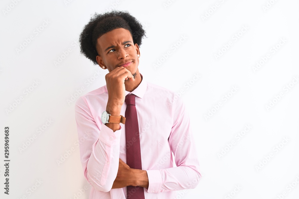 Young african american businessman wearing tie standing over isolated white background with hand on chin thinking about question, pensive expression. Smiling with thoughtful face. Doubt concept. Young african american businessman wearing tie standing over isolated white background with hand on chin thinking about question, pensive expression. Smiling with thoughtful face. Doubt concept.