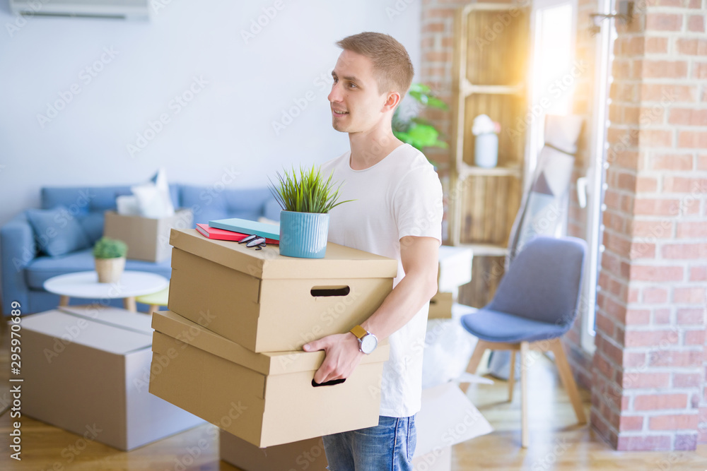Young handsome man moving cardboard boxes at new home Young handsome man moving cardboard boxes at new home