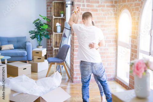 Young beautiful couple dancing at new home around cardboard boxes © Krakenimages.com