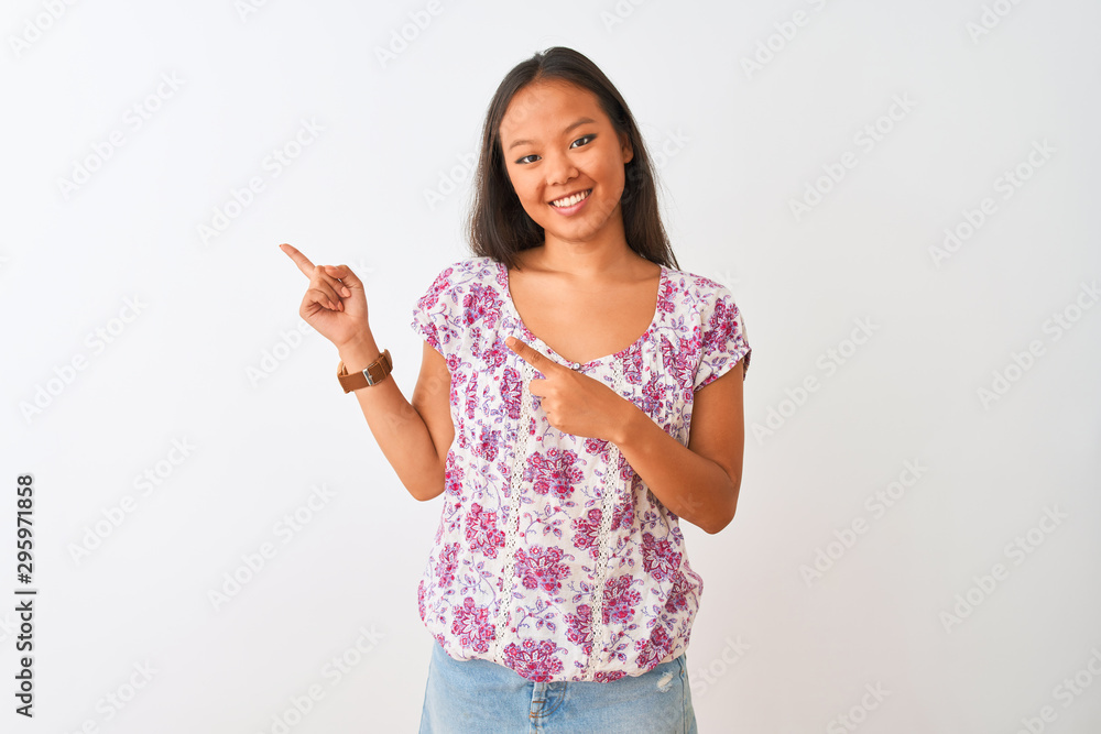 Young chinese woman wearing casual floral t-shirt standing over isolated white background smiling and looking at the camera pointing with two hands and fingers to the side. Young chinese woman wearing casual floral t-shirt standing over isolated white background smiling and looking at the camera pointing with two hands and fingers to the side.