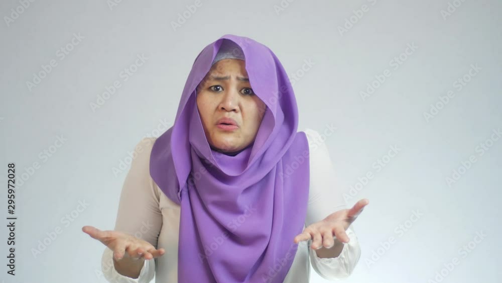 Beautiful Asian muslim woman shrugging shoulder, denial or I don't know gesture, refused to be blamed concept Beautiful Asian muslim woman shrugging shoulder, denial or I don't know gesture, refused to be blamed concept