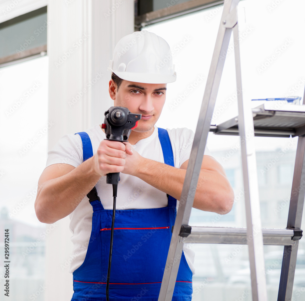 Repairman working with power drill in workshop Repairman working with power drill in workshop