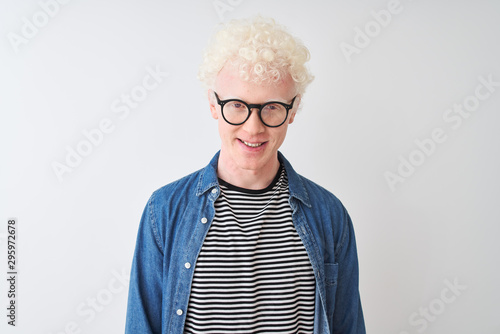 Young albino blond man wearing denim shirt and glasses over isolated white background with a happy and cool smile on face. Lucky person.
