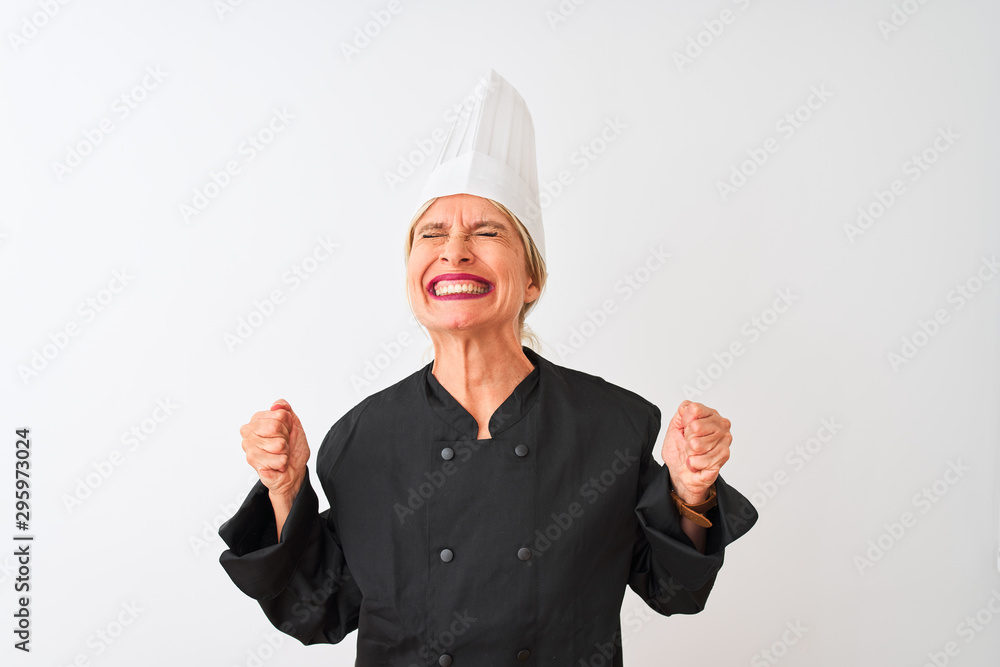 Middle age chef woman wearing uniform and hat standing over isolated white background very happy and excited doing winner gesture with arms raised, smiling and screaming for success Middle age chef woman wearing uniform and hat standing over isolated white background very happy and excited doing winner gesture with arms raised, smiling and screaming for success