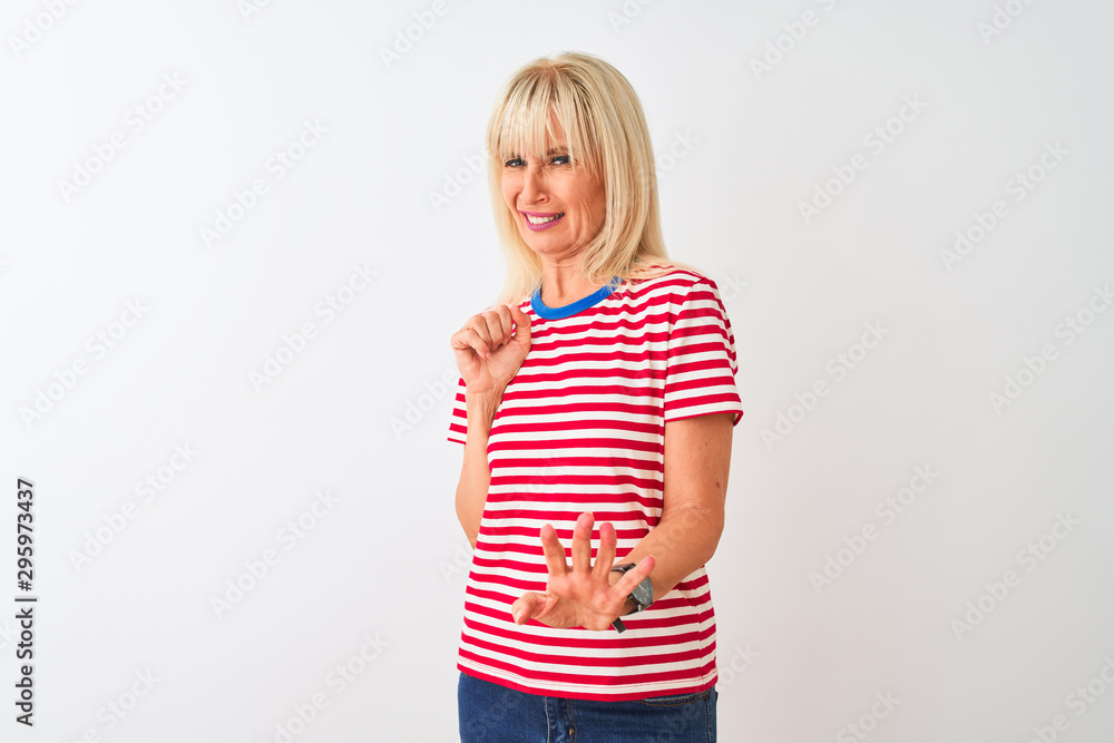 Middle age woman wearing casual striped t-shirt standing over isolated white background disgusted expression, displeased and fearful doing disgust face because aversion reaction. With hands raised Middle age woman wearing casual striped t-shirt standing over isolated white background disgusted expression, displeased and fearful doing disgust face because aversion reaction. With hands raised