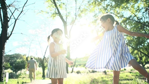 手を繋いで公園で遊ぶ姉妹