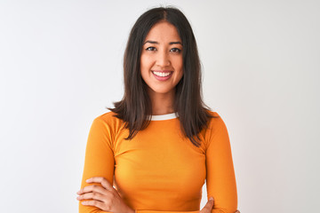 Young beautiful chinese woman wearing orange t-shirt standing over isolated white background happy face smiling with crossed arms looking at the camera. Positive person.