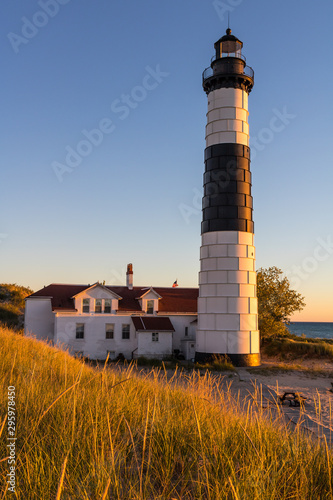 lighthouse at sunset with beach grass