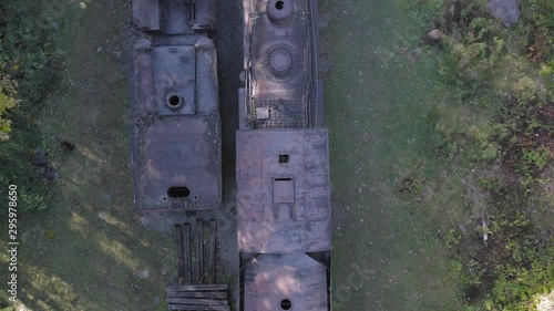 Ascending top down aerial over abandoned steam trains within wilderness 4K photo