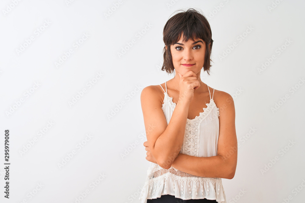 Young beautiful woman wearing summer casual t-shirt standing over isolated white background looking confident at the camera with smile with crossed arms and hand raised on chin. Thinking positive. Young beautiful woman wearing summer casual t-shirt standing over isolated white background looking confident at the camera with smile with crossed arms and hand raised on chin. Thinking positive.