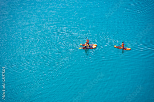 Tourists enjoy in the stand up paddle on the water