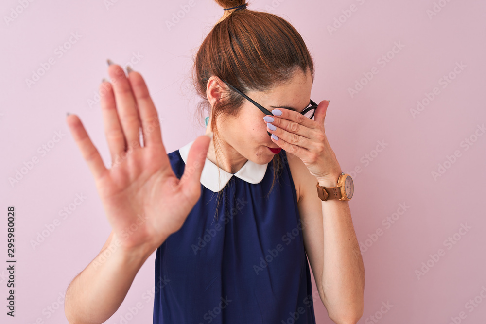Redhead woman with pigtail wearing elegant dress and glasses over isolated pink background covering eyes with hands and doing stop gesture with sad and fear expression. Embarrassed Redhead woman with pigtail wearing elegant dress and glasses over isolated pink background covering eyes with hands and doing stop gesture with sad and fear expression. Embarrassed